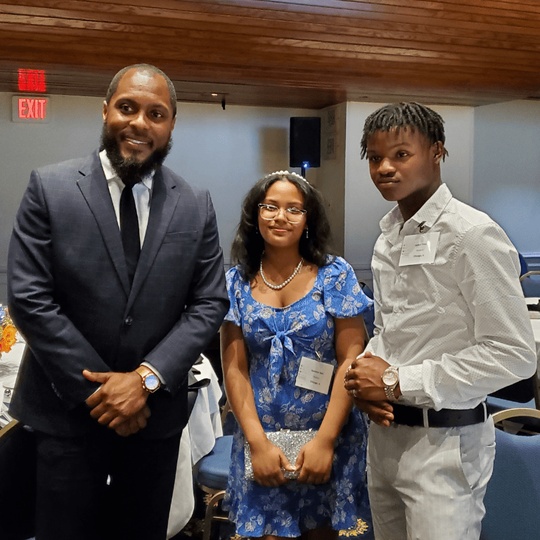 Students stand with keynote speaker at recognition dinner