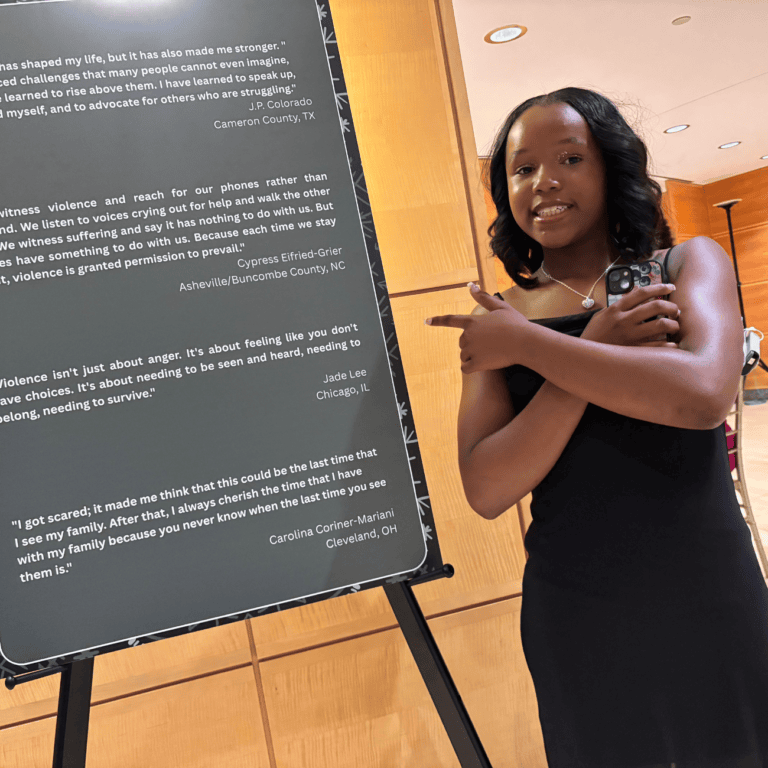 Jade stands next to sign with an excerpt from her essay
